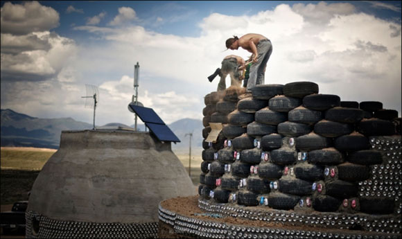Packing Earthship tyre walls with earth